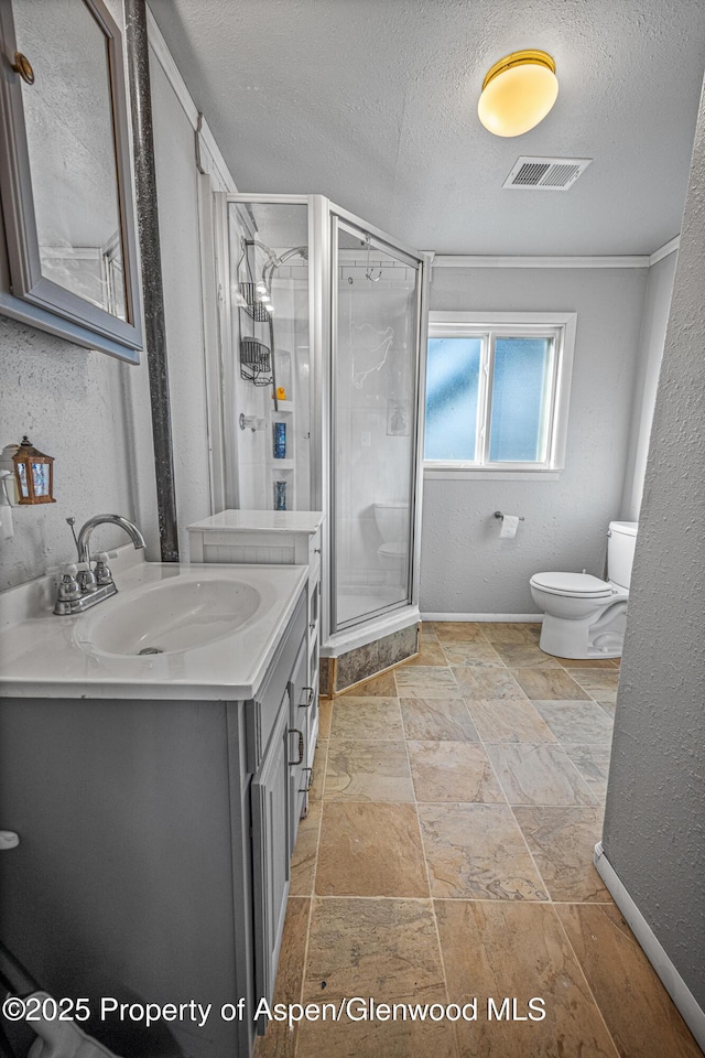 bathroom featuring visible vents, a shower stall, toilet, vanity, and a textured ceiling