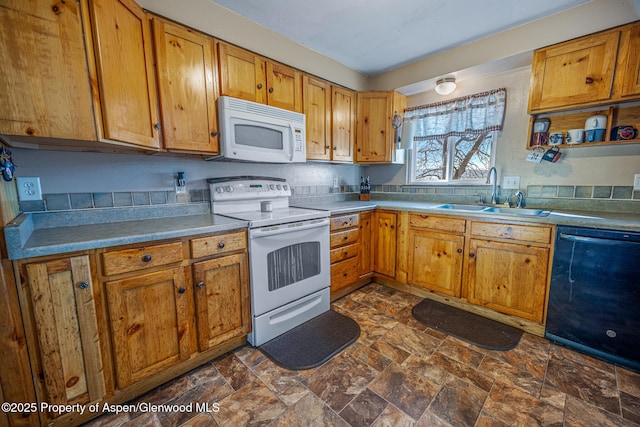 kitchen featuring white appliances, stone finish floor, brown cabinetry, and a sink