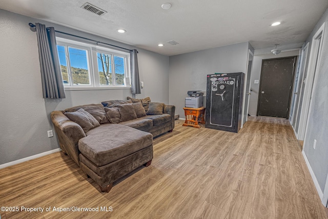 living room featuring recessed lighting, visible vents, baseboards, and light wood finished floors