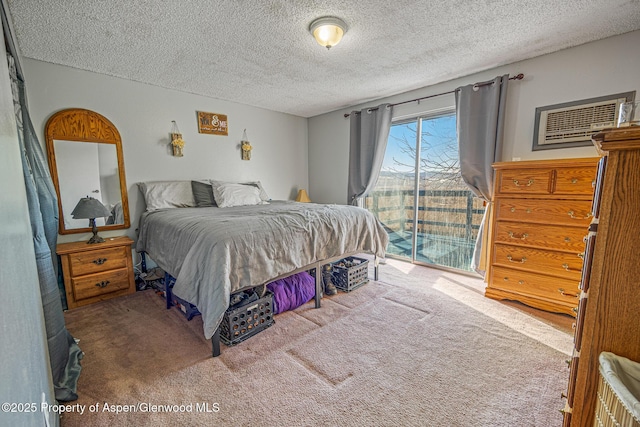 bedroom featuring access to outside, carpet, and a textured ceiling