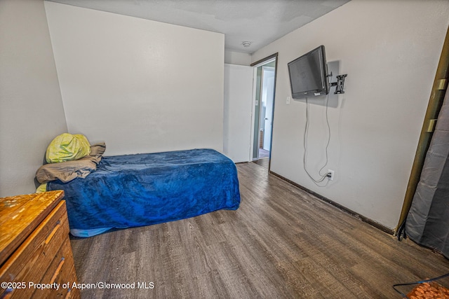 bedroom with baseboards and wood finished floors