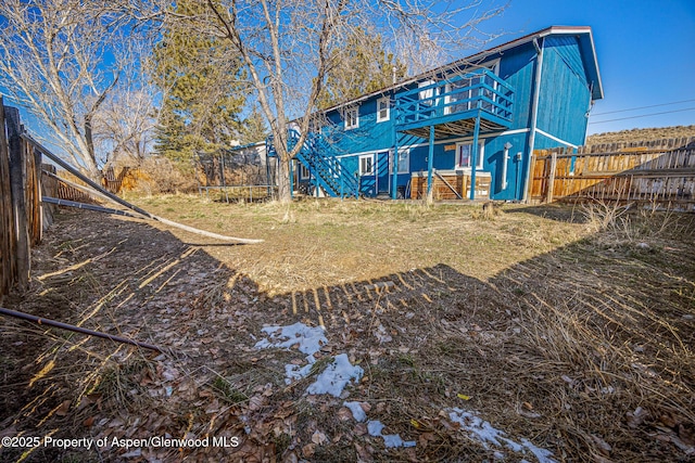 rear view of property featuring a fenced backyard and a trampoline