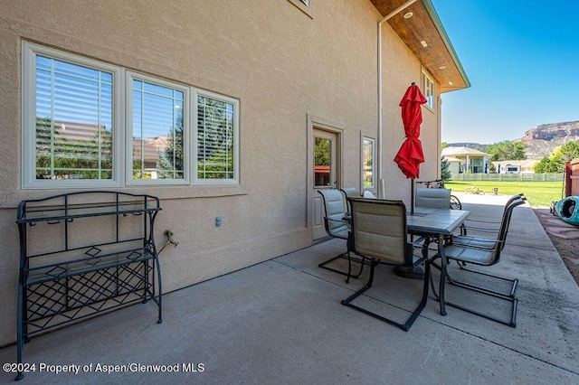 view of patio with a mountain view and outdoor dining space