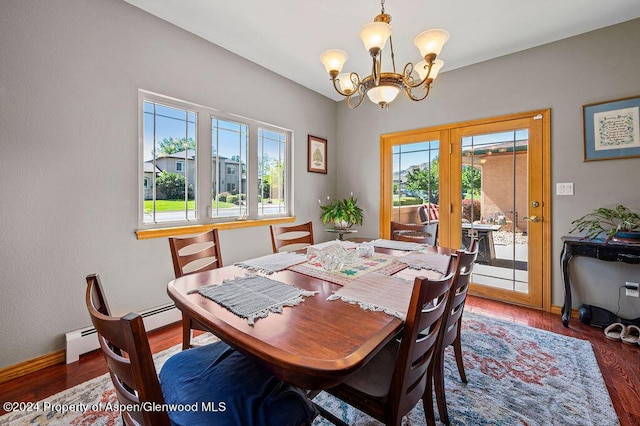 dining area featuring a baseboard heating unit, a notable chandelier, wood finished floors, and baseboards