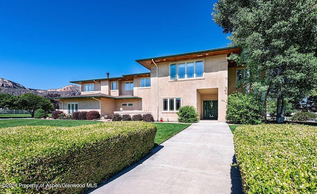 view of front of property featuring stucco siding and a front lawn