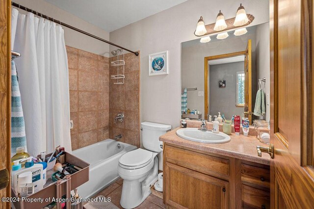 full bath featuring vanity, tile patterned floors, toilet, and shower / bath combo with shower curtain