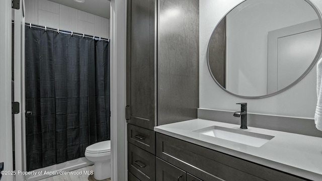 full bath featuring toilet, curtained shower, and vanity