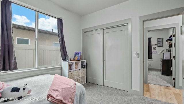 bedroom with baseboards, a closet, and wood finished floors