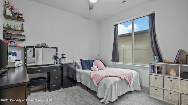 carpeted bedroom featuring a ceiling fan and visible vents