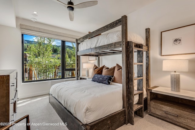 carpeted bedroom featuring baseboards and ceiling fan