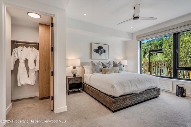 bedroom featuring recessed lighting, a walk in closet, baseboards, and carpet floors