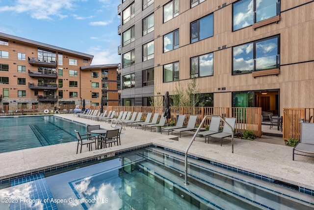 view of pool featuring a patio, a community hot tub, and fence