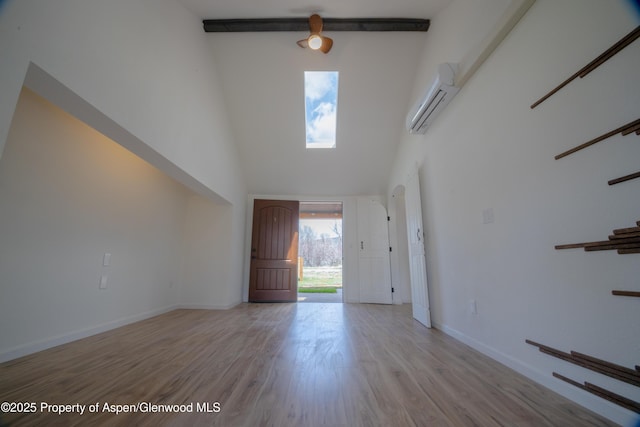 foyer with a wall mounted AC, light hardwood / wood-style floors, and a high ceiling