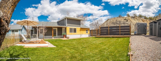 rear view of house with a lawn and a deck