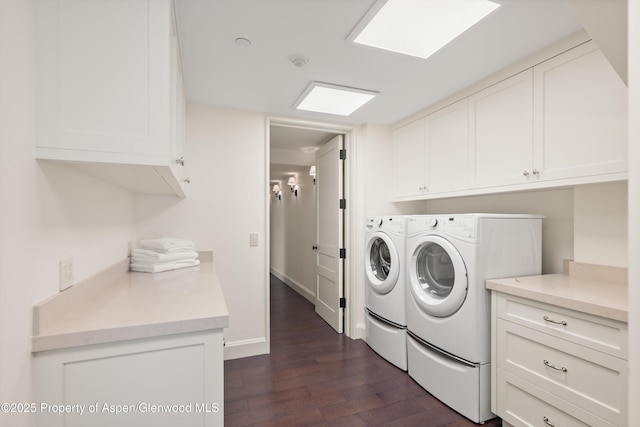 laundry room featuring washer and dryer, dark wood-style flooring, cabinet space, and baseboards