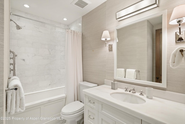 bathroom featuring toilet, vanity, shower / bath combination with curtain, and visible vents