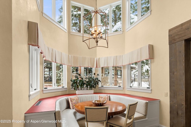 dining area with breakfast area, a chandelier, visible vents, and a healthy amount of sunlight