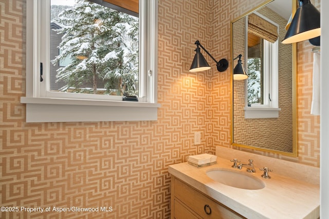 bathroom with wallpapered walls and vanity