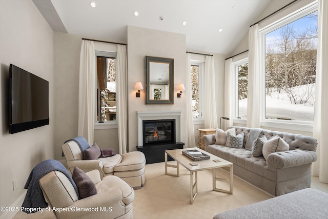 living room with lofted ceiling, a glass covered fireplace, and recessed lighting