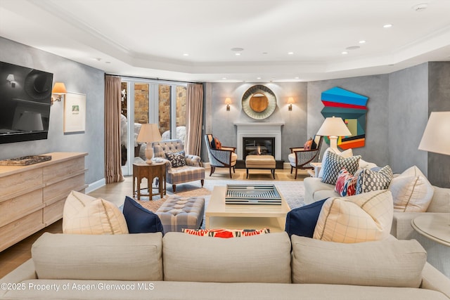 living room with wood finished floors, a glass covered fireplace, and recessed lighting