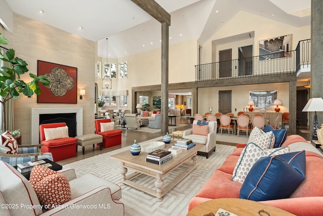 living area with recessed lighting, a large fireplace, and a towering ceiling