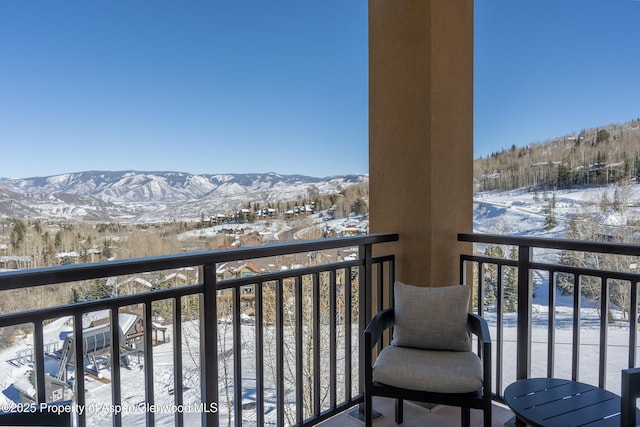 snow covered back of property featuring a mountain view