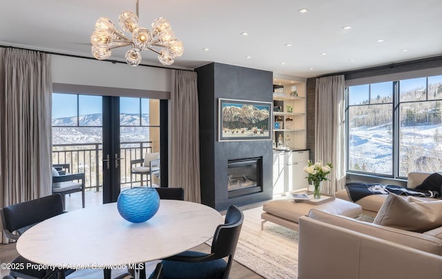 living room featuring a mountain view, a large fireplace, a healthy amount of sunlight, and french doors