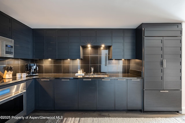 kitchen featuring wall oven, sink, and decorative backsplash