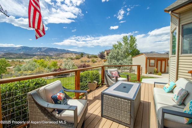 1783 Anvil View Ave, Rifle, CO 81650 - deck featuring an outdoor living space with a fire pit, a mountain view, and an outdoor structure