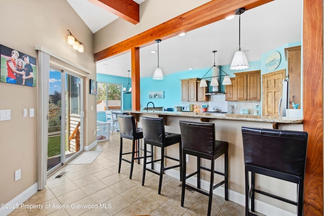 1783 Anvil View Ave, Rifle, CO 81650 - kitchen featuring beamed ceiling, wall chimney exhaust hood, a kitchen bar, a peninsula, and light stone counters