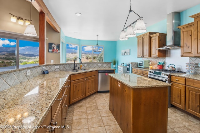 1783 Anvil View Ave, Rifle, CO 81650 - kitchen featuring appliances with stainless steel finishes, wall chimney range hood, backsplash, a kitchen island, and a chandelier