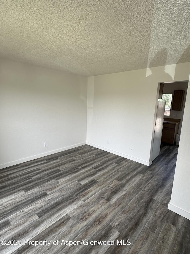 3865 W 6th St, Craig, CO 81625 - spare room featuring dark wood-type flooring and a textured ceiling