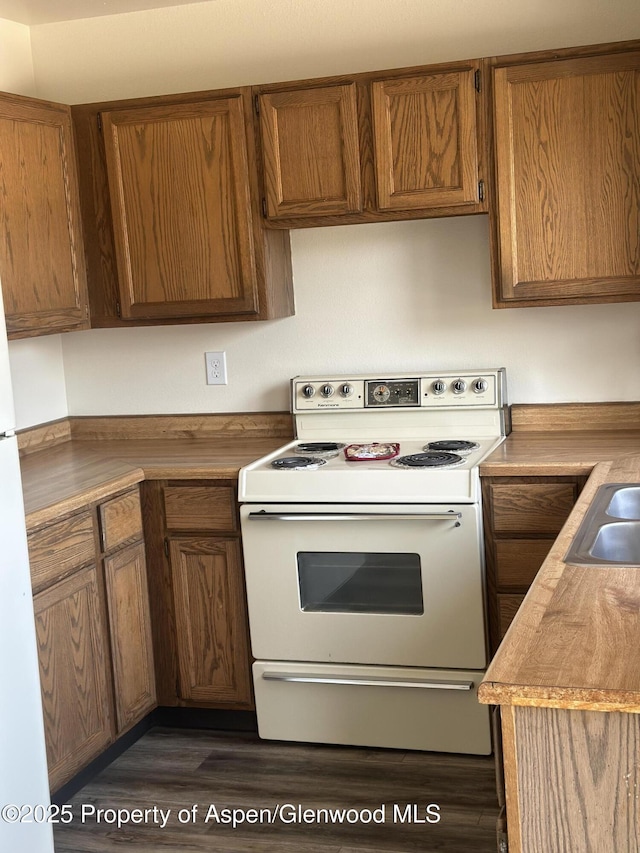 3865 W 6th St, Craig, CO 81625 - kitchen with white electric stove, dark wood-style floors, and brown cabinets