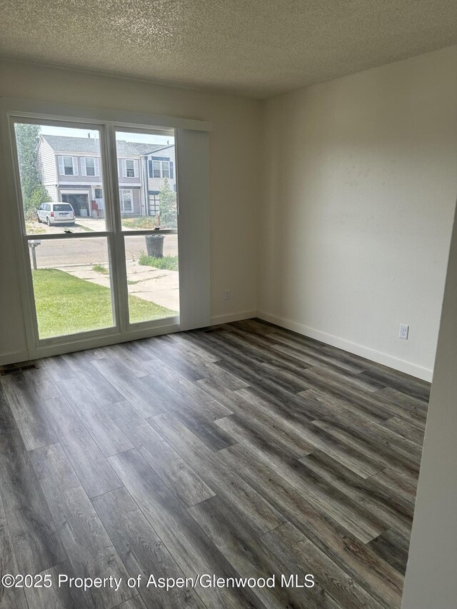 3865 W 6th St, Craig, CO 81625 - unfurnished room with dark wood finished floors and a textured ceiling