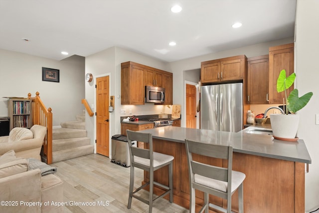 287 Southside Dr, Basalt, CO 81621 - kitchen featuring appliances with stainless steel finishes, a peninsula, open floor plan, a kitchen breakfast bar, and light wood finished floors