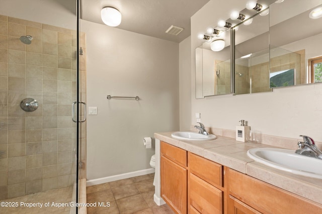 287 Southside Dr, Basalt, CO 81621 - bathroom featuring a shower stall, toilet, double vanity, tile patterned floors, and baseboards