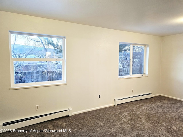 carpeted empty room featuring baseboard heating