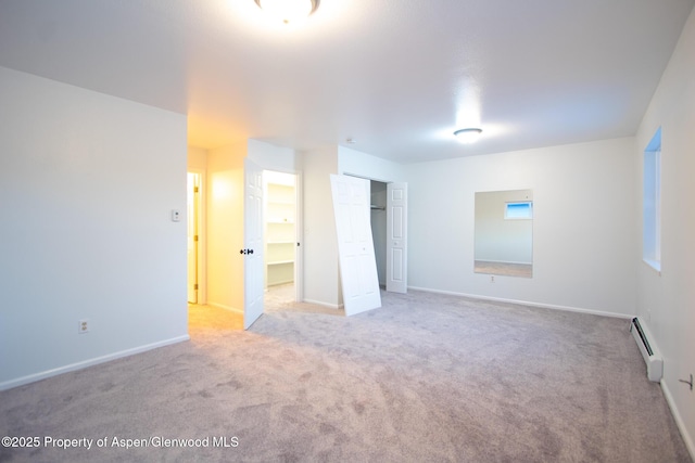 carpeted empty room with a baseboard radiator