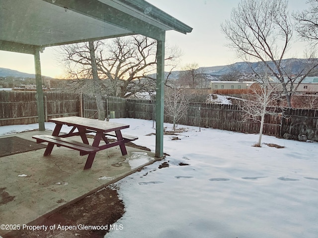 yard layered in snow featuring a mountain view