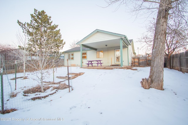 snow covered property featuring covered porch