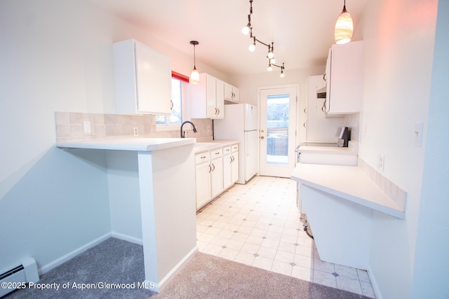 kitchen with stove, a baseboard radiator, white cabinets, and hanging light fixtures