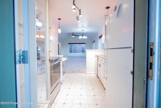 kitchen with hanging light fixtures, stainless steel electric range oven, light colored carpet, white cabinetry, and white fridge