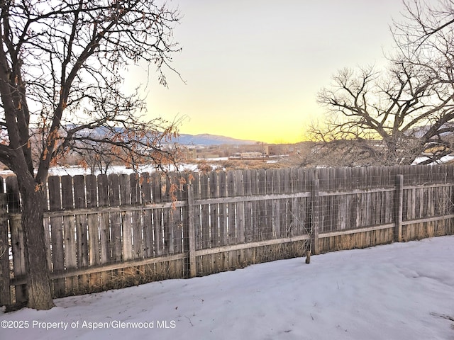 yard covered in snow featuring a mountain view