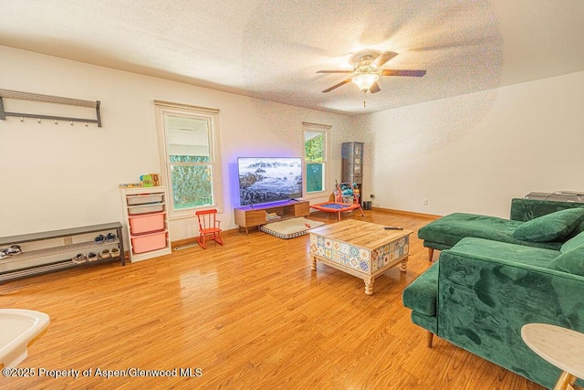 living area featuring ceiling fan, a textured ceiling, and wood finished floors