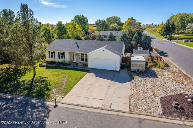 single story home featuring an attached garage, a front yard, and concrete driveway