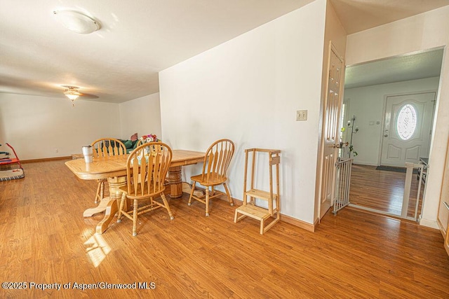 dining space featuring baseboards and light wood-style flooring
