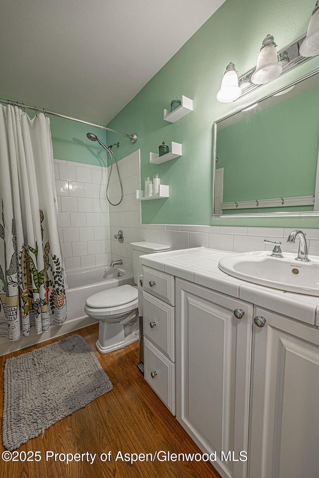 full bath featuring vanity, shower / bathtub combination with curtain, toilet, and wood finished floors