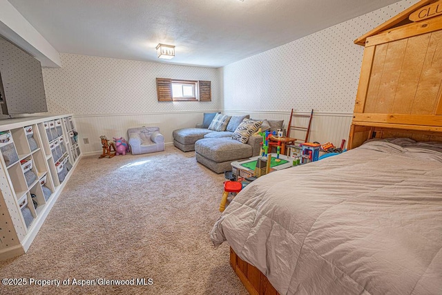 carpeted bedroom featuring a wainscoted wall and wallpapered walls
