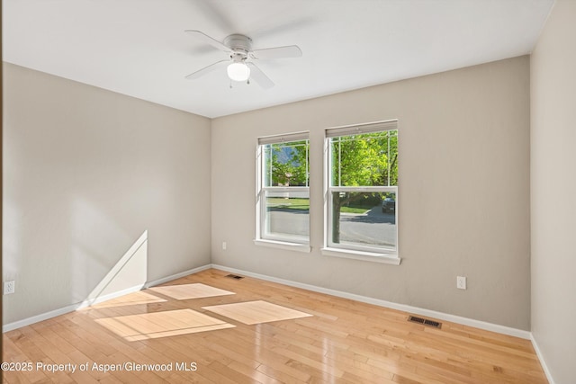 unfurnished room featuring ceiling fan, hardwood / wood-style flooring, and baseboards