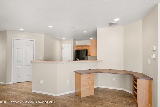 kitchen featuring freestanding refrigerator, light wood-style floors, baseboards, recessed lighting, and a peninsula
